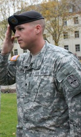 Heath in US Army uniform and beret, saluting at his reenlistment ceremony in 2010