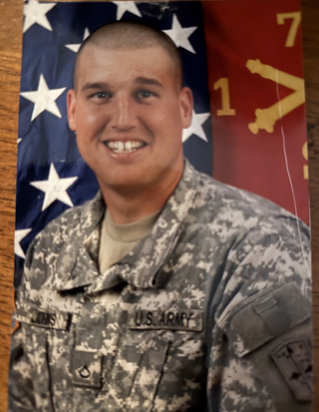 Heath in US Army combat uniform, portrait in front of an American flag